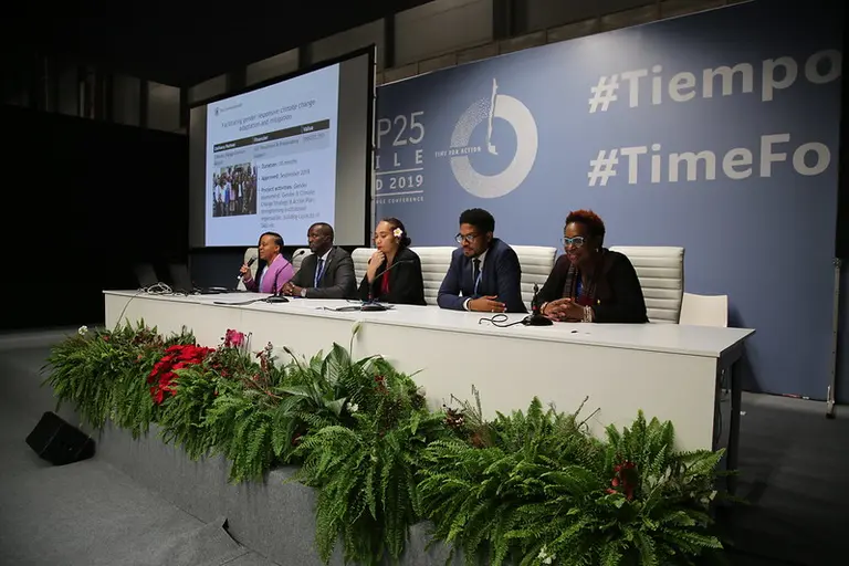 Five people sitting on a table delivering a presentation