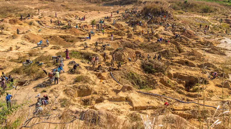 Aerial view of hundreds of men and women tin mining