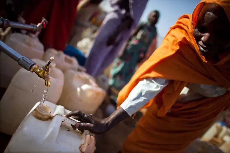 Woman filling a jerry can with water