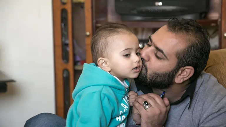 Firas kissing his son Mohammad