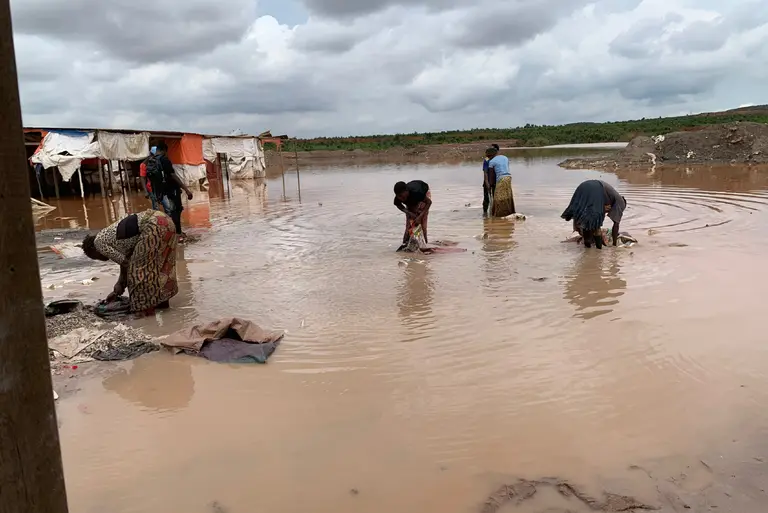 Women stand in water washing cobalt