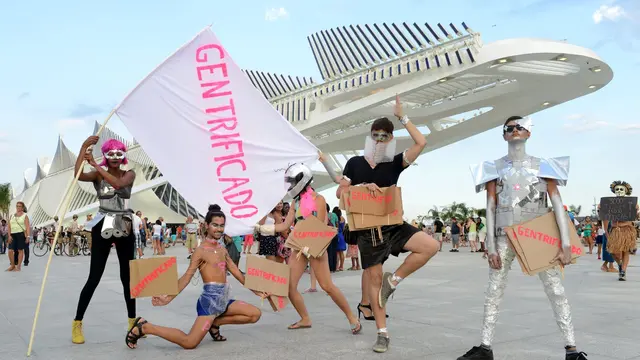 Five people posing with signs that read "gentrificado"