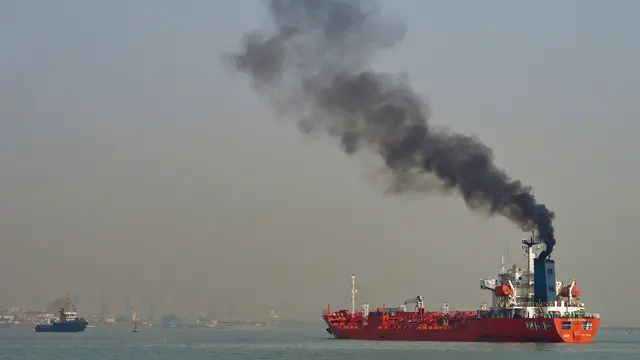 Black polluting smoke billows from a ship. 