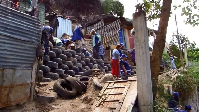 People building a wall out of disused tyres.