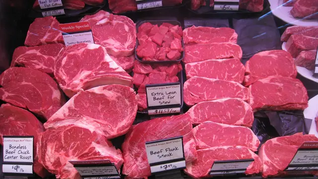Slabs of beef are displayed on supermarket shelves.