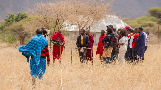 A group of people gather in a field.