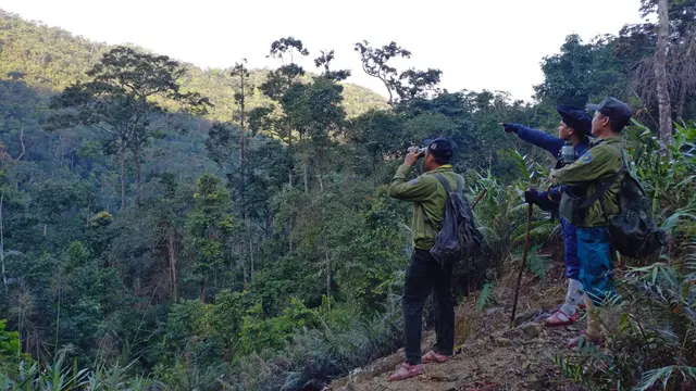 Two men surveying a hilly landscape.