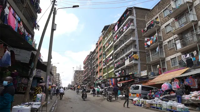Street scene with multistorey flats and market stalls.