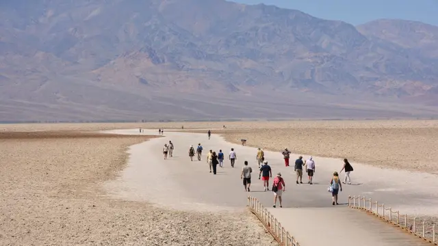 Group of tourist walking into an open space desert in Death Valley.