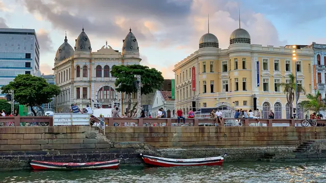 Waterfront with boats and people walking in Recife, Brazil.