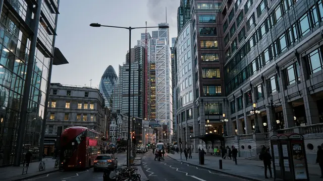 London street during night time, with cars on the roads and people walking on the side walks.