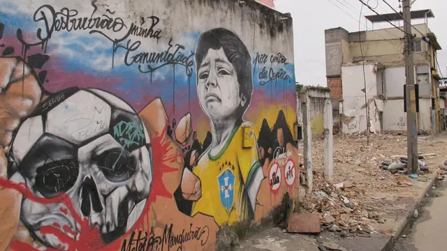 Image of grafitti of child crying on a building in Favela Metro-Mangueira. The buildings next to it are torn down.