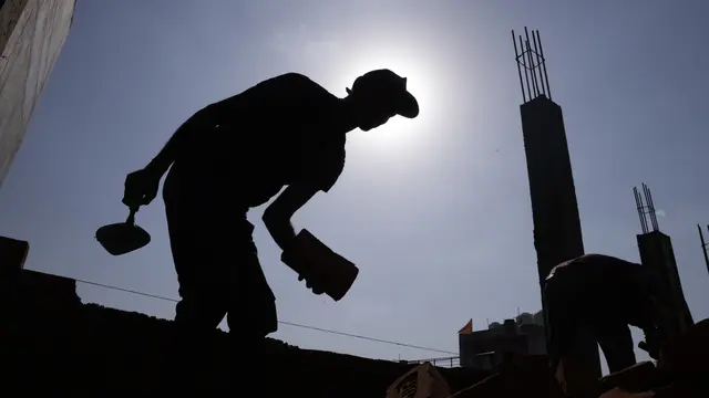 A builder labours in the sun in India. Outdoor workers lose weeks of work every year due to extreme heat