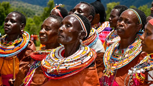 A group of women in colourful clothes, pride written on their faces, sing.
