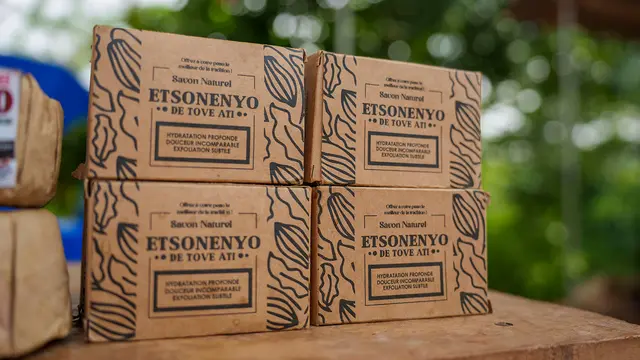 Four brown boxes of soap are stacked on a table.