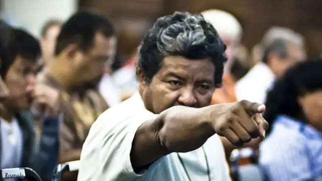 A man points his finger at someone in a meeting room at a debate at a meeting on the sustainable development of the Amazon at Rio+20.