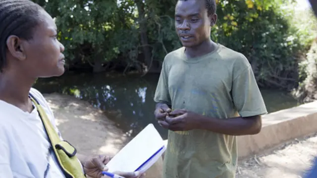 A researcher speaks to a cotton farmer in Mozambique. 