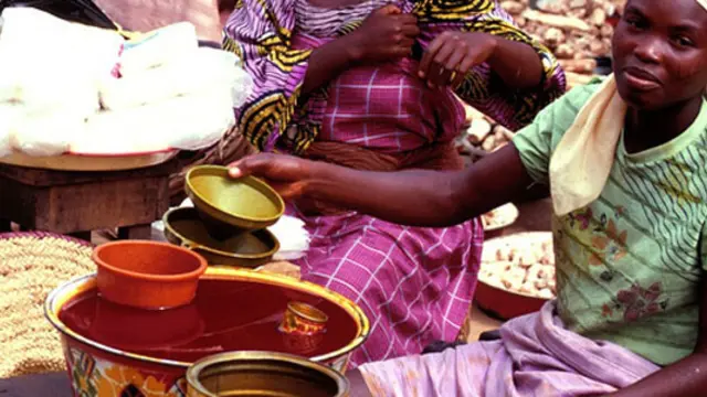 A woman sells palm oil in a market in west Africa.
