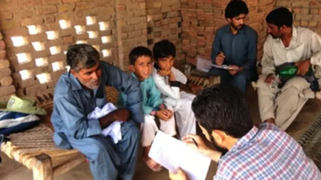 Researchers talk to villagers in Sheikhuwal village in rural Pakistan