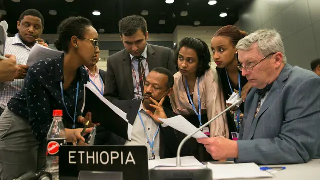 Delegates from the LDC Group, including chair Gebru Jember Endalew and IIED's Achala Abeysinghe discuss the revised APA text, Bonn, May 2017 (Photo: IISD/ENB/Kiara Worth)