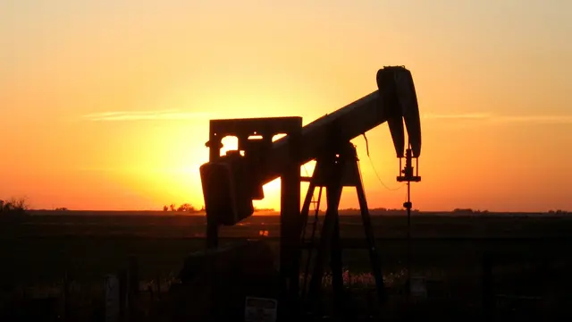 An oil rig silhouetted at sunset