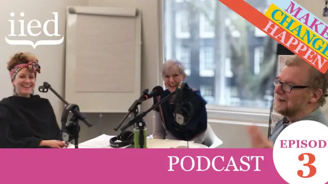 Three people sat around a table speaking into microphones