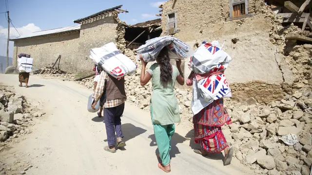 Women carrying emergency shelter kits