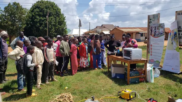 A crowd gathers outside to see a presentation 