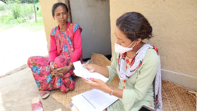 A data collector speaks to a householder.