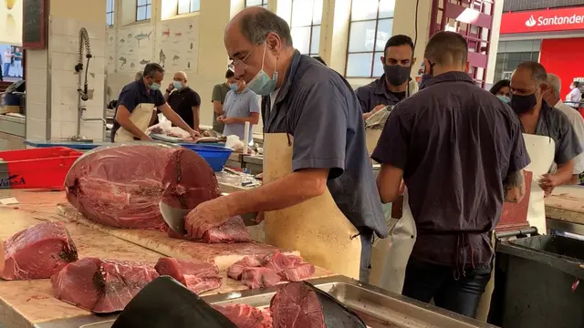 Vendor cutting fish in the market.