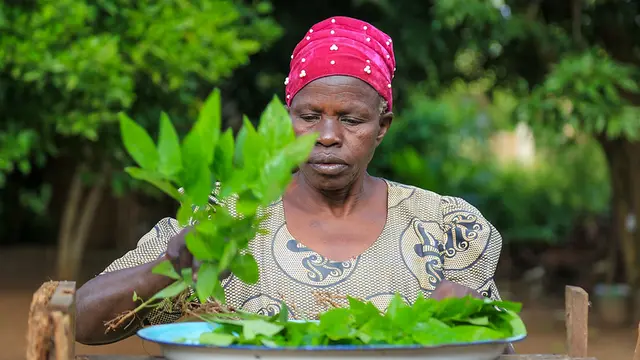 Woman puts greens on a plate