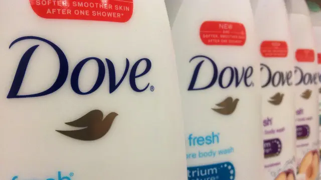 A close-up photo of a row of Dove soap bottles, focusing on the first bottle with others in a column behind.