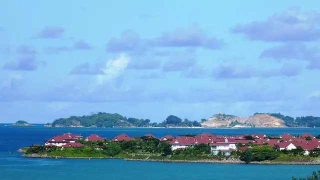 Landscape of an island with houses and vegetation surrounded by the sea.