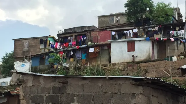 Clothes hang on lines outside small poorly maintained houses