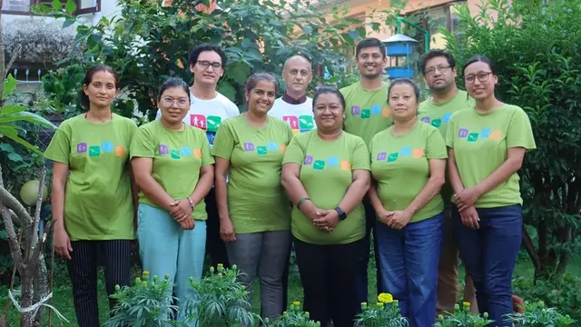 Group of people wearing green T-shirts pose for a picture.