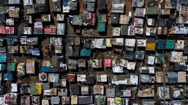 An aerial view of dozens of shack housing in close proximity, with colourful roofs
