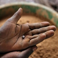 A small lump of metal sits in the palm of an outstretched hand