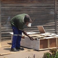 Man painting wooden furniture.