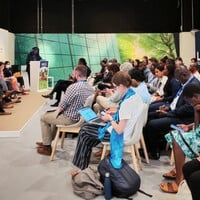 A panel speaking in front of an audience.