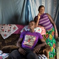 Two people sitting on a couch in a room.