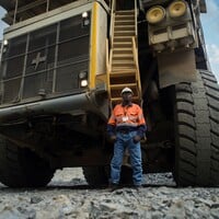 A man standing in front of a large truck.