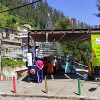 People standing next to a juice stand in the outdoors.