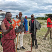 A man demonstrating an apparatus to several people.