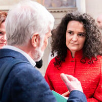 A woman talks engagedly with a man with his back to the camera.