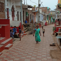 Image showing the fishing community slum of Sai Baba Sahi after the construction, with a main street paved with stones, houses and shops. 