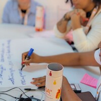 Workshop participants discussing and writing ideas down on flipchart paper.