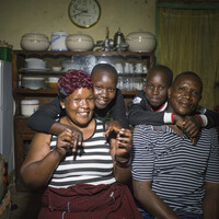 14. Wellington Moses – dump truck operator at Getia Gold Mine – with his family at their home in Geita town