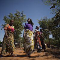 15. Local businesswomen arrive to buy sacks filled with gold ore that have just been extracted from the tunnels of Nsangano Gold Mine