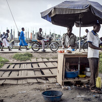 After buying flour and cooking oil in the local shop next to his house, Chris prepares chapattis and sells them to people along the road (Photo: Sven Torfinn/Panos Pictures)