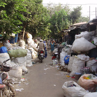 A row of self-built dwellings called jhuggies with bags of recyclables from the landfill site (Photo: Pritpal Randhawa for STEPs)